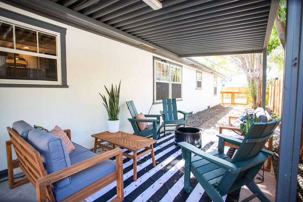 Patio seating area with smokeless fire pit at this three-bedroom, two-bathroom mid-century house that sleeps 8 and boasts a unique experience in color, style, and lifestyle products located in the heart of Waco, TX.