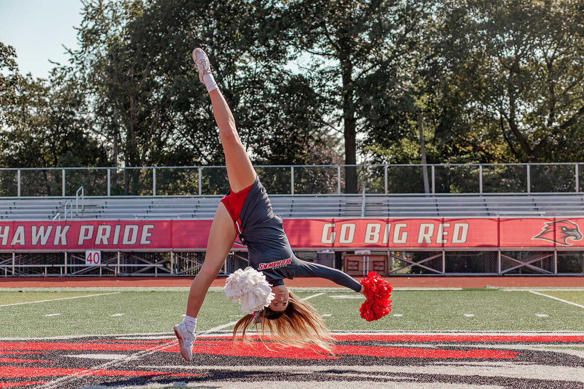 Cheerleading tumbling on football field action photography