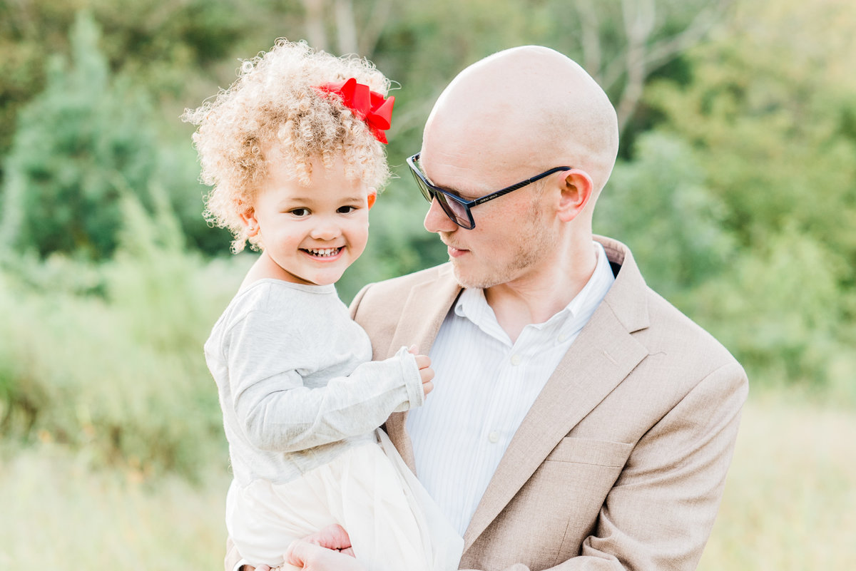 Dad and daughter snuggle for a photo during a Raleigh NC family photography session. Photographed by Raleigh family photographer A.J. Dunlap Photography.