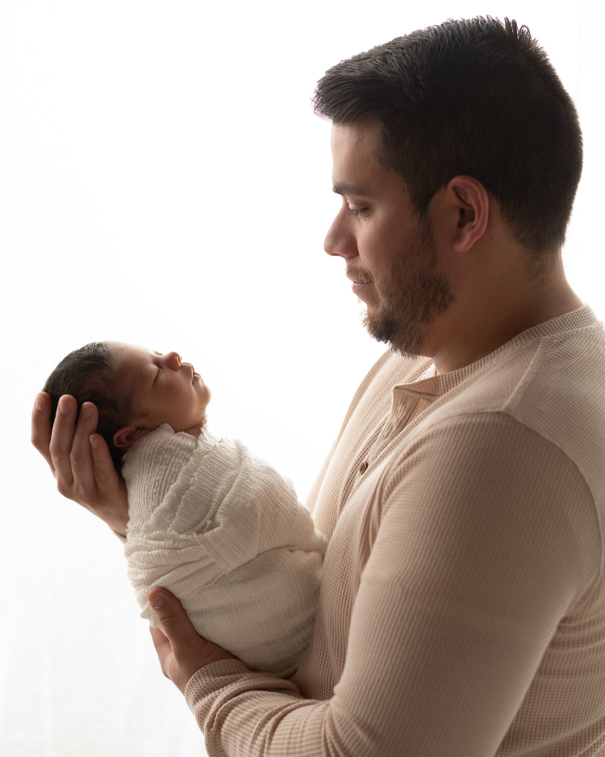 dad holding son for newborn photoshoot
