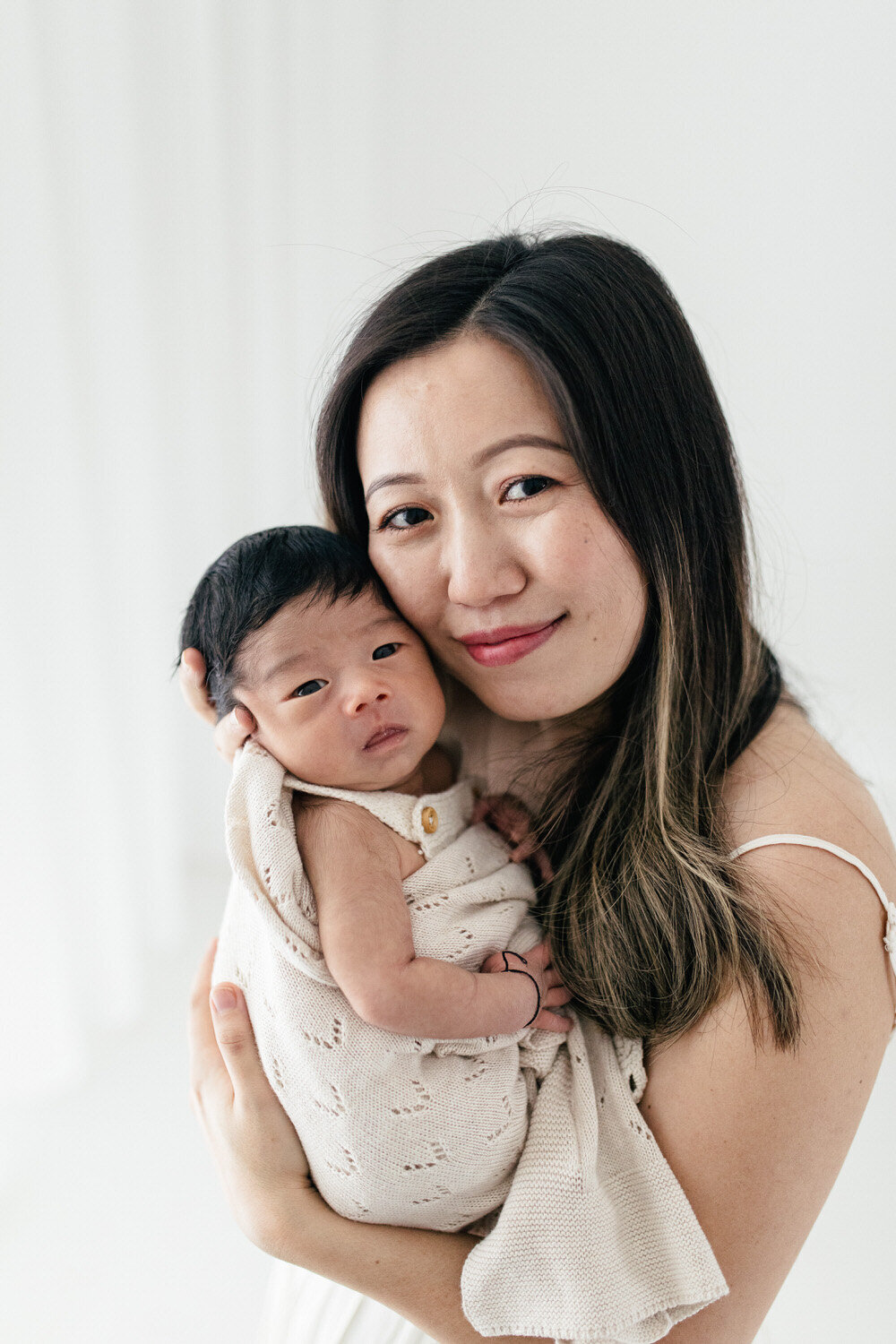 baby and mum pose together and look at the camera