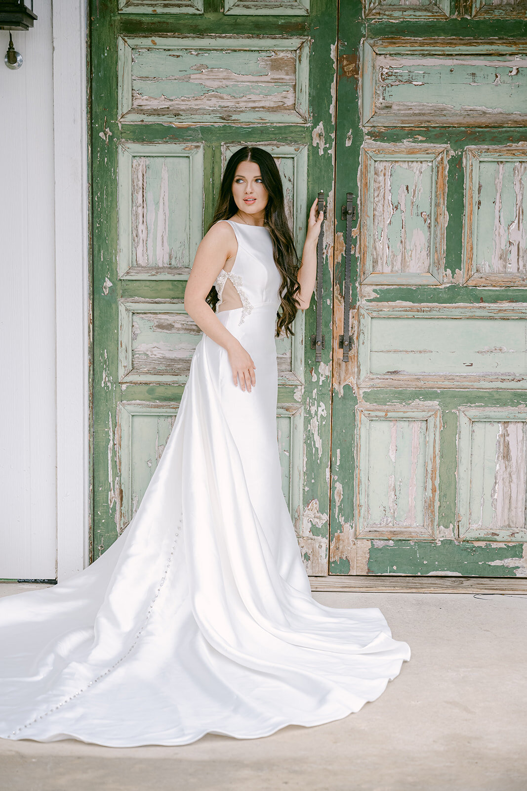 Austin wedding photographer captures bride in sculptural gown in front of The Videre Estate’s signature green doors.