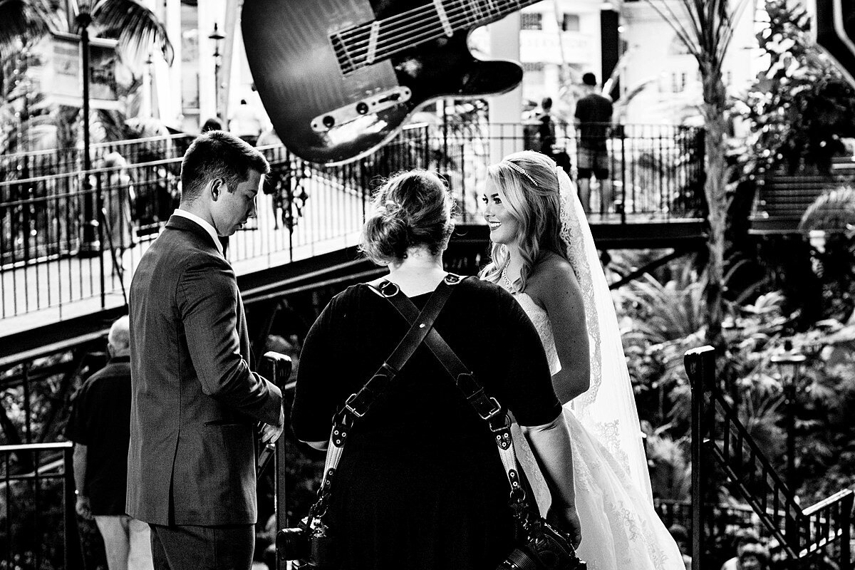 Black and White photo of Mahlia chatting with bride and groom on their wedding day