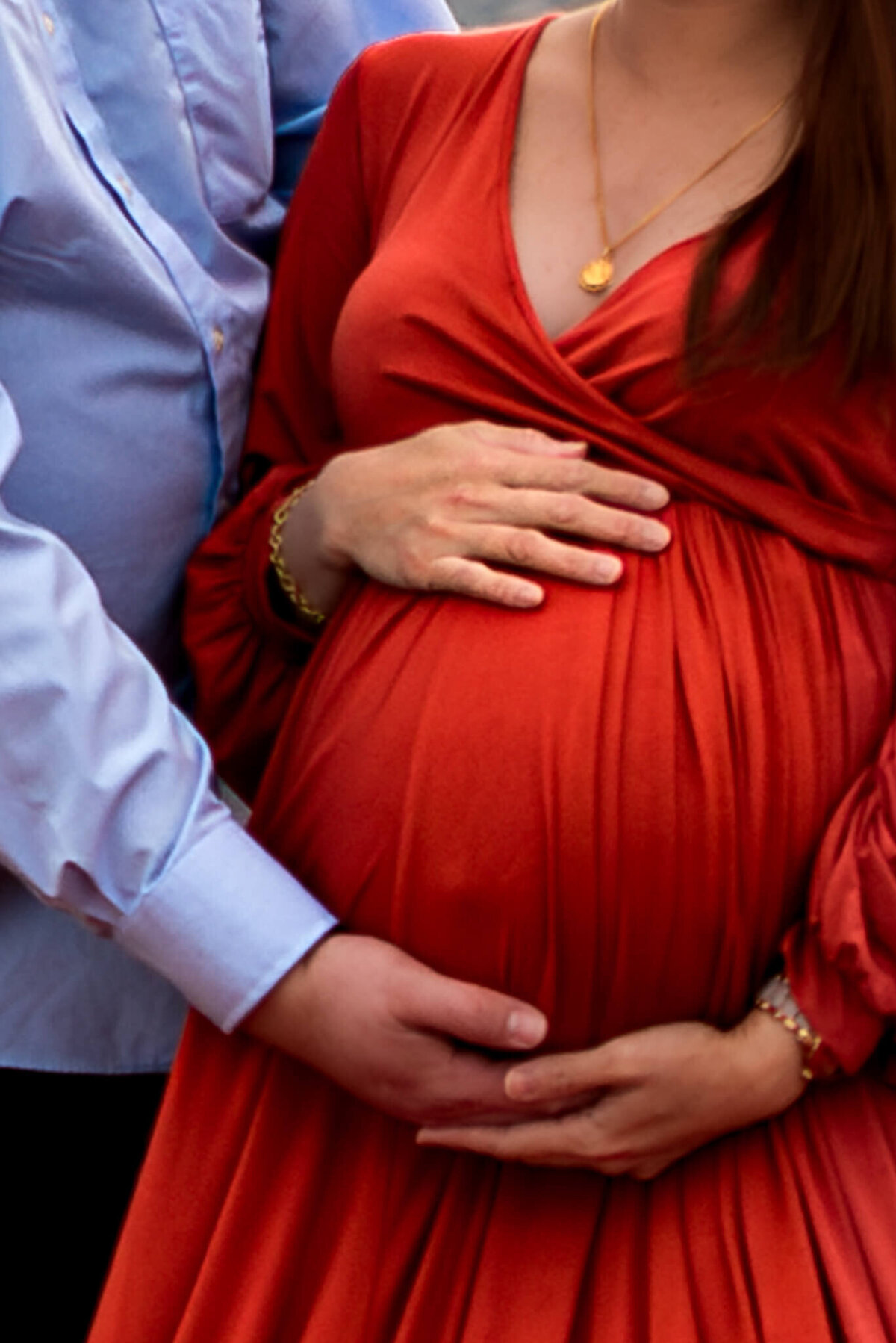 Intimate moment of expecting parents holding baby bump. Close up by Cactus & Pine Photography