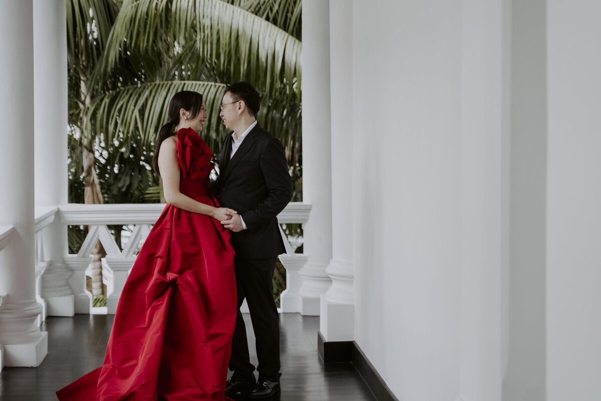 bride wearing red cheongsam dress and groom wearing a black suit hold hands