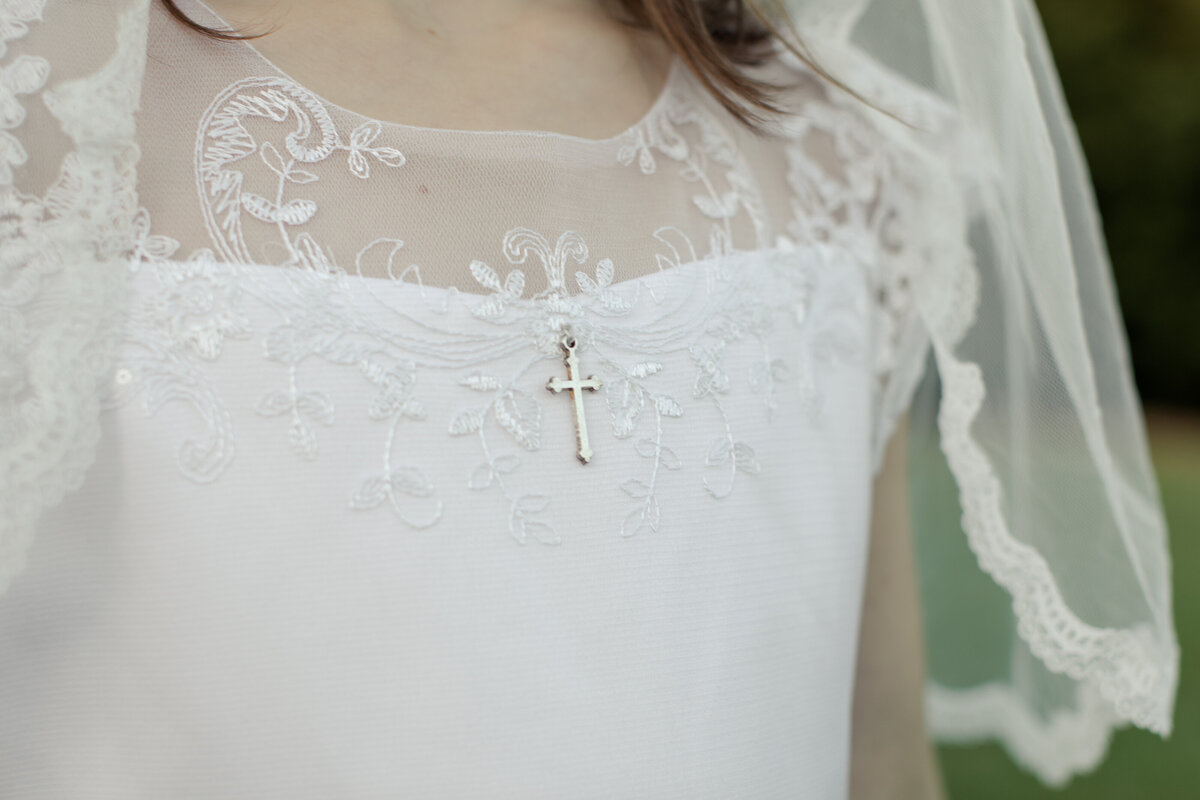 detail shot of a cross on a white dress