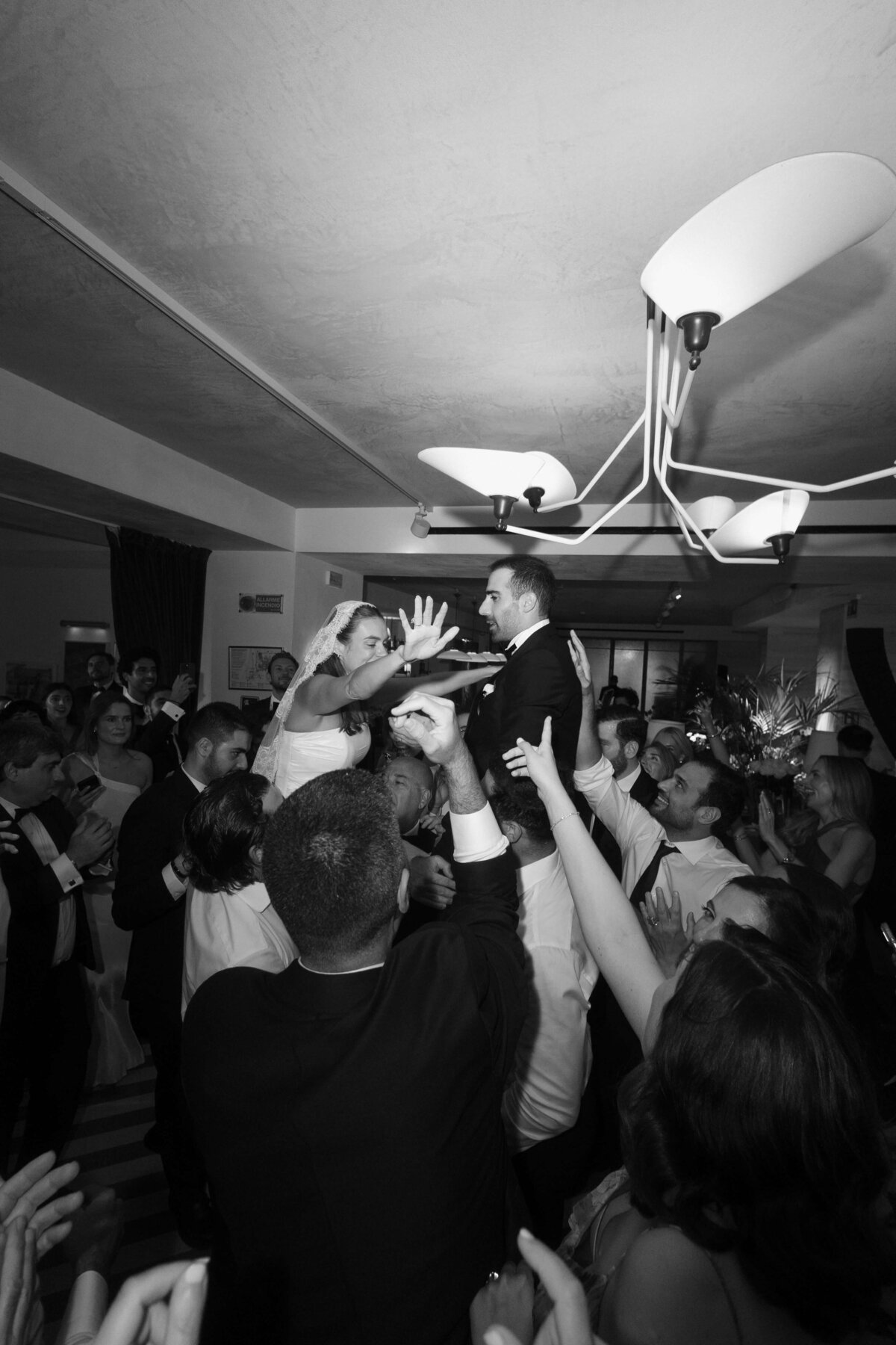 Guests cheering and clapping around bride during party celebration

