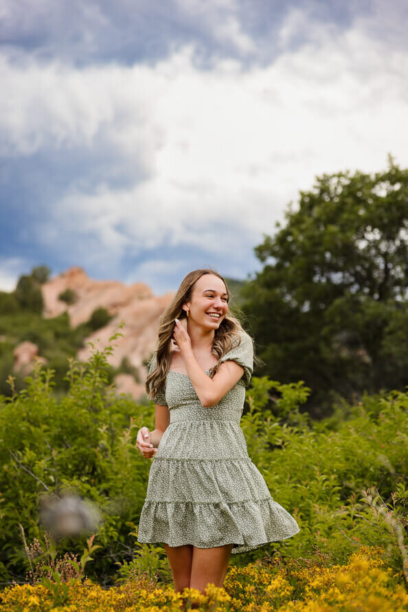 Girl looks off camera with rock formations behind her.