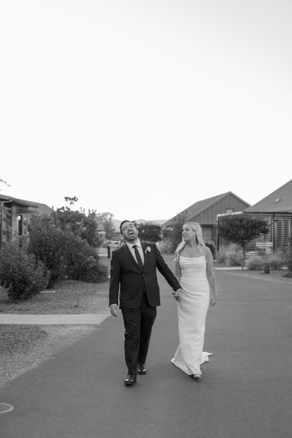 happy groom walking with bride in napa valley at an auberge property