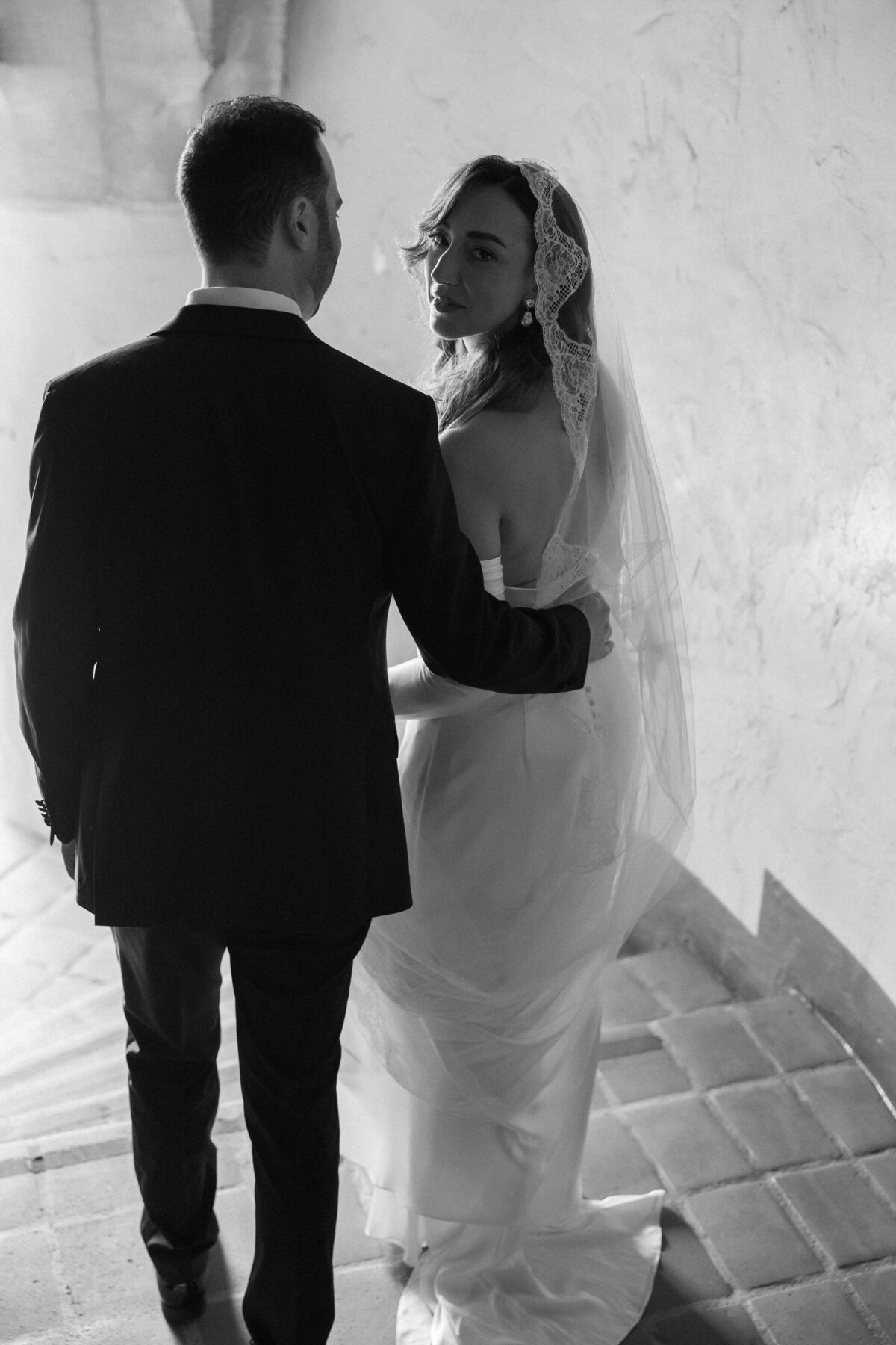 bride in vintage lace veil walking down stairs of the santa barbara courthouse