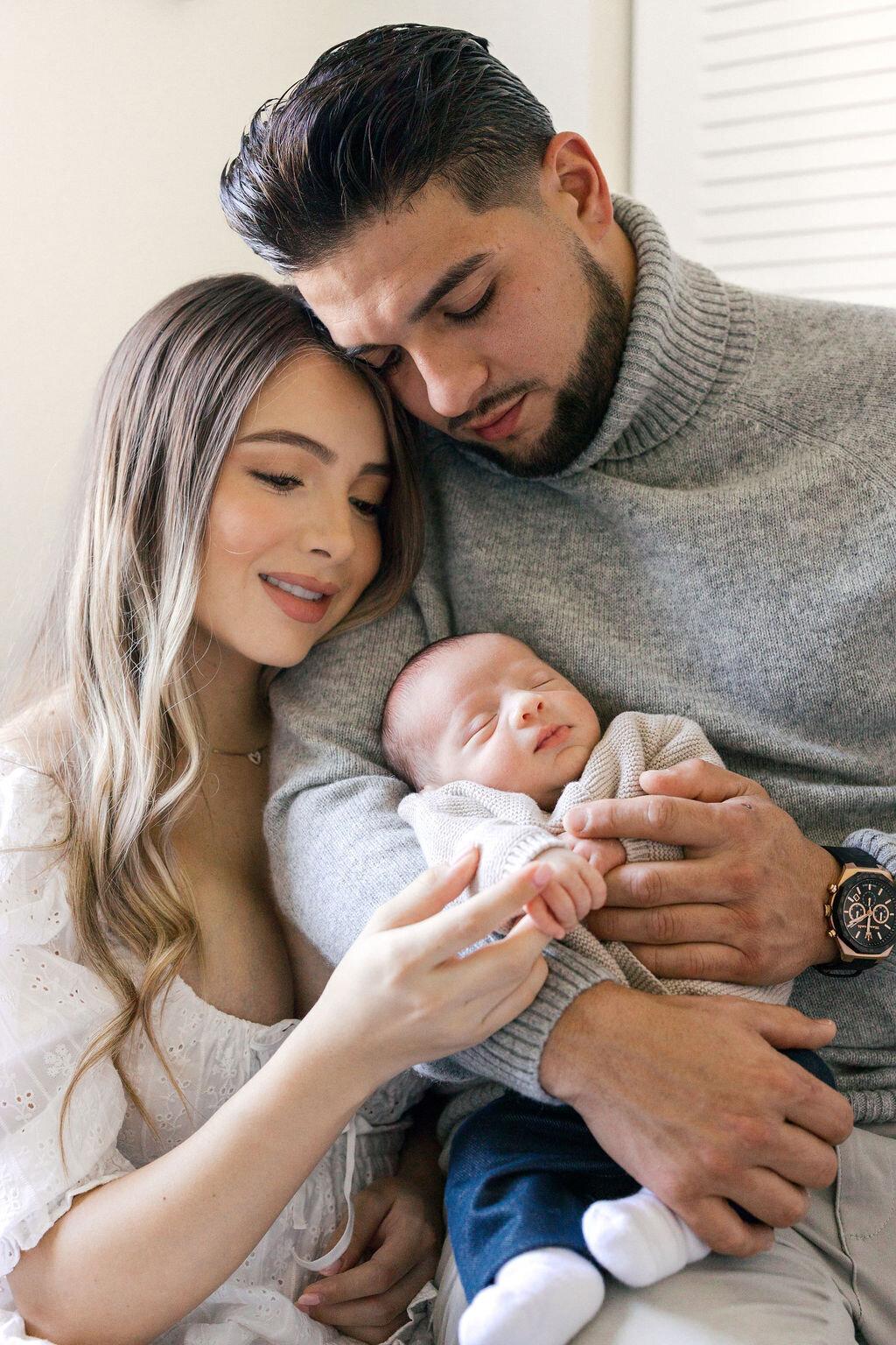 Parents holding newborn baby during a cozy in-home lifestyle photography session in Fort Lauderdale, Florida.
