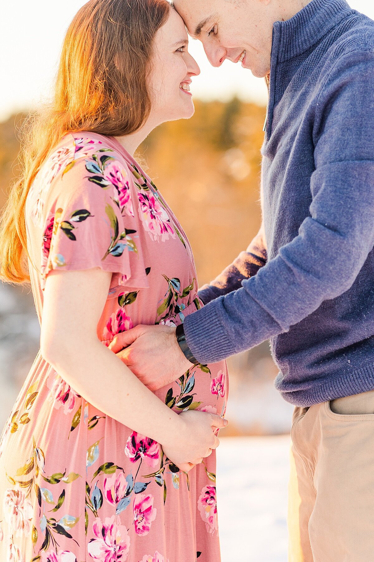 man holds womans belly during winter maternity photo session with Sara Sniderman Photography In Natick Massachusetts