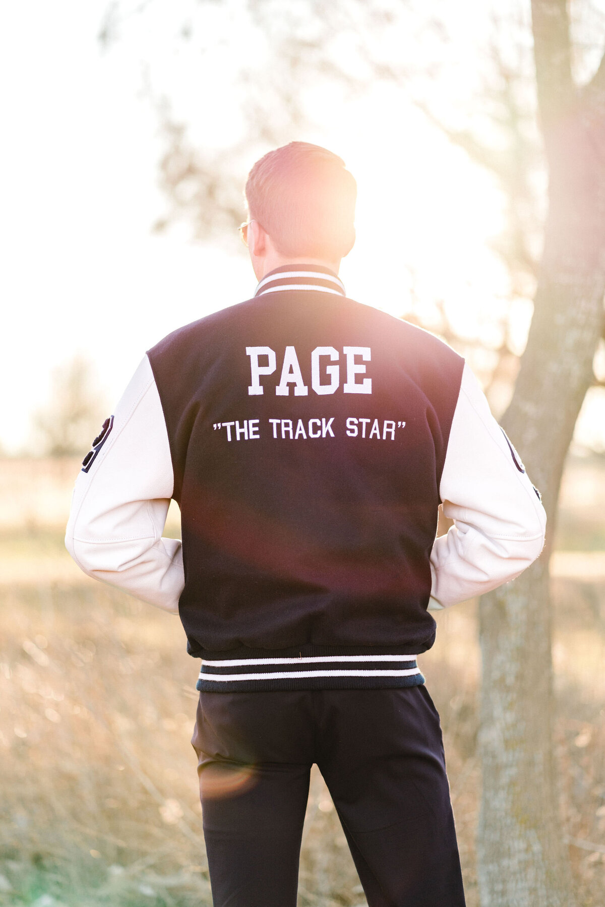 Austin senior boy in letterman jacket. Outside in Austin Texas.