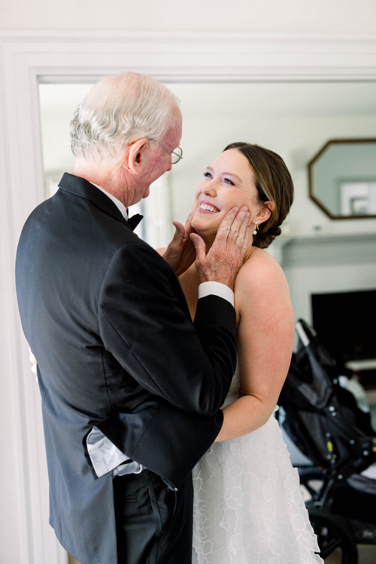 father holding brides face in hands