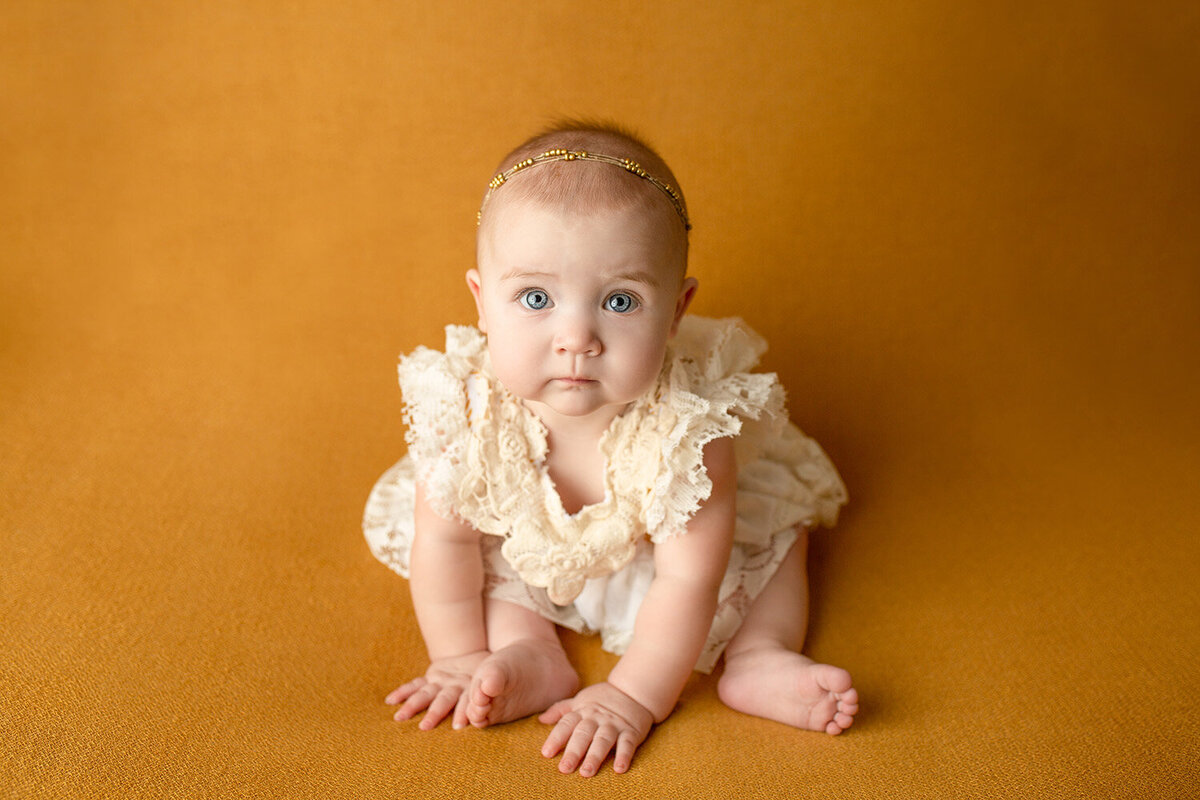 Baby in dress on yellow canvas