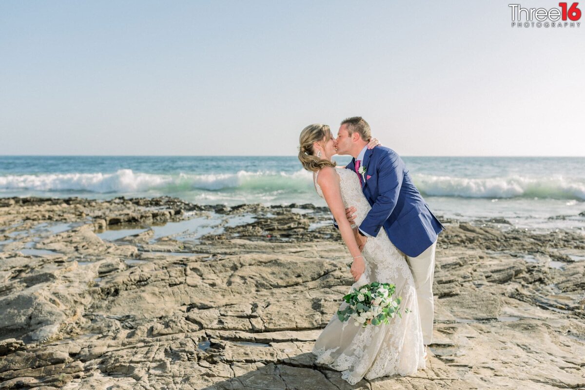 Groom leans in and kisses his Bride during the photo shoot on the beach