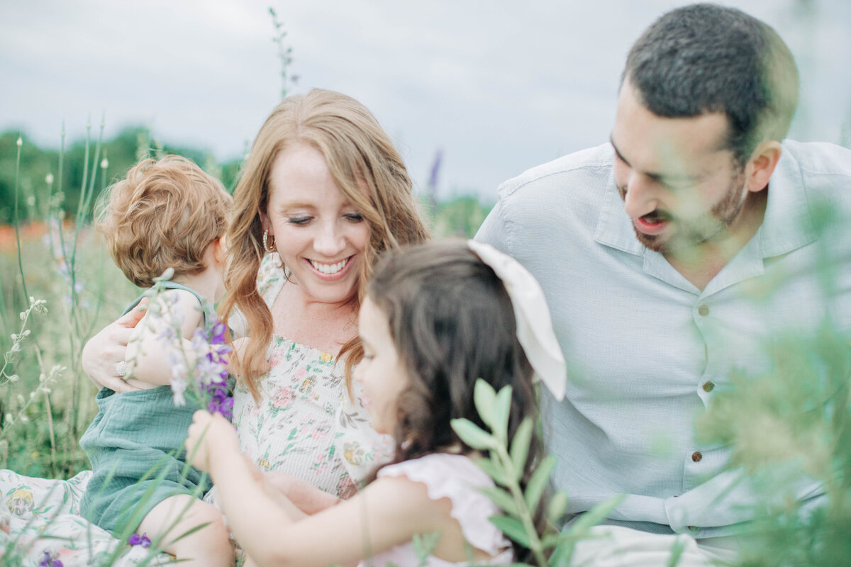 family sitting in flower field