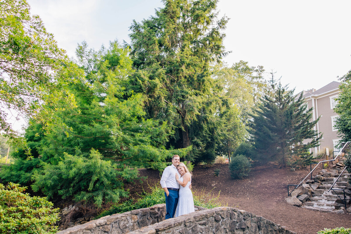 couple holding each other on bridge at rock quarry in south carolina