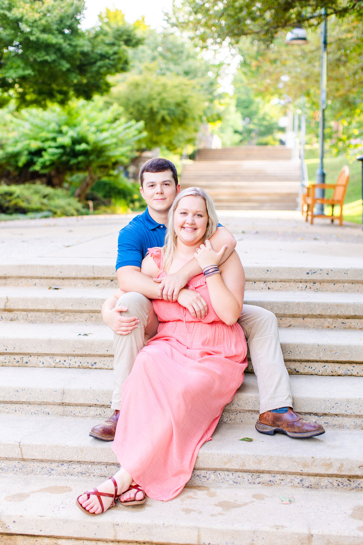 couple hugging and posing together on steps at NC Arboretum