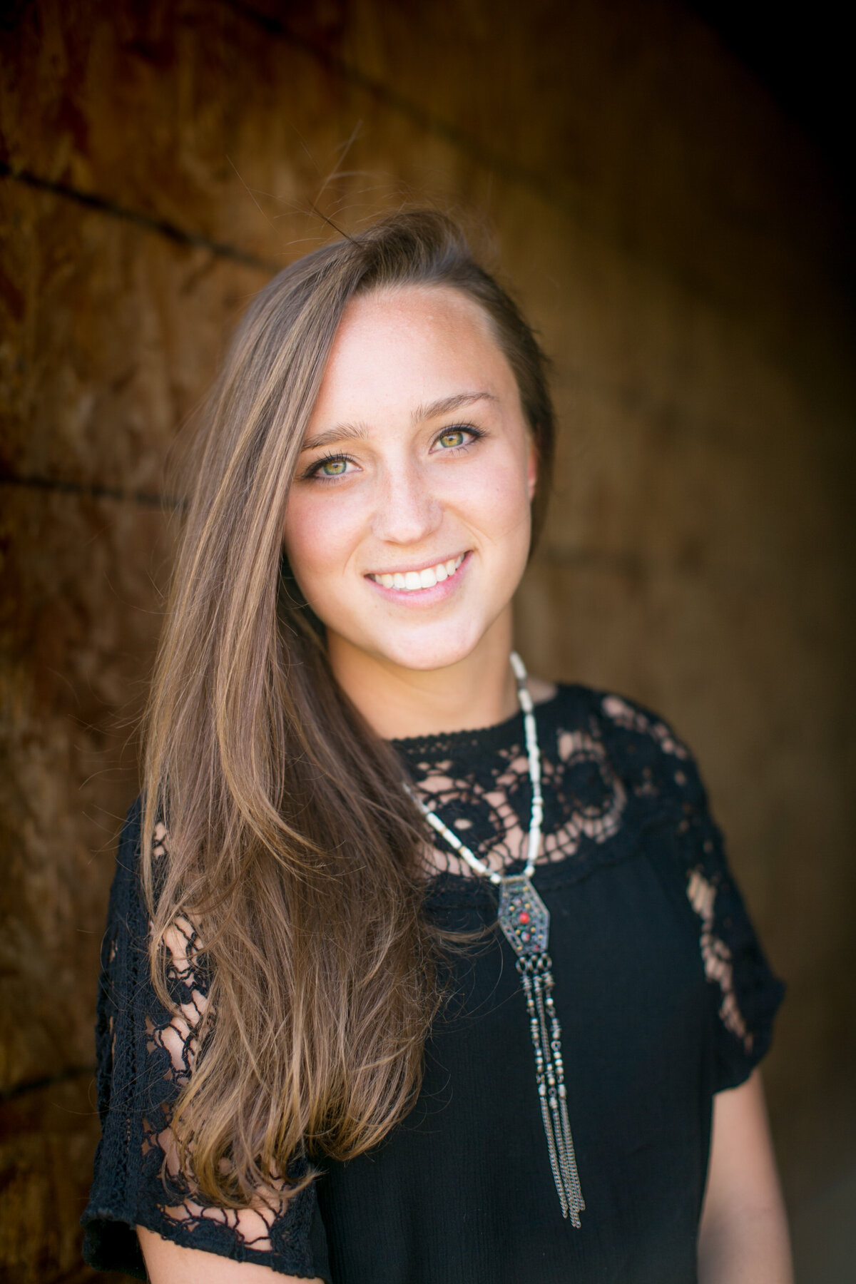 brunette with pretty eyes poses for her senior portrait