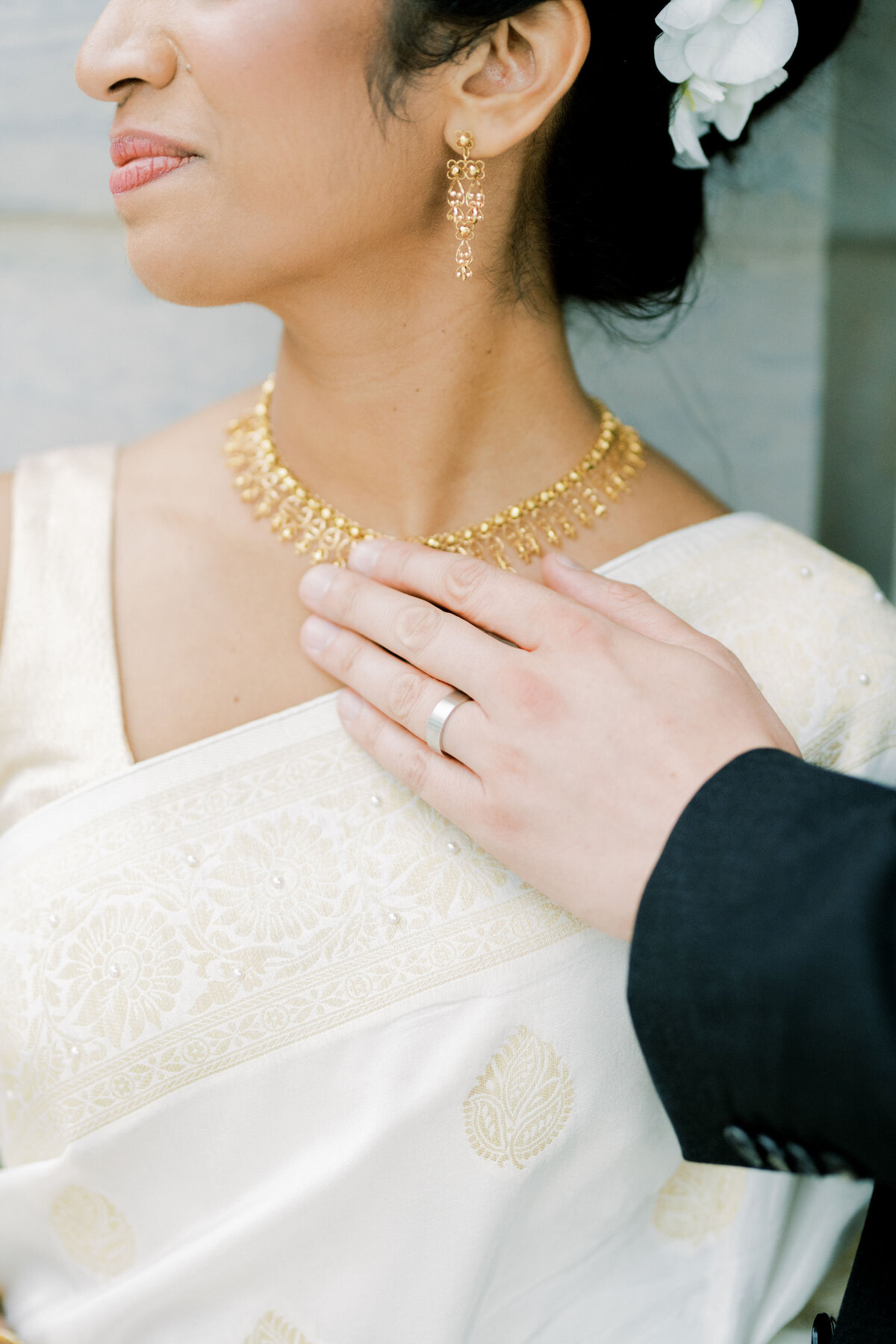 groom touching brides necklace just hands