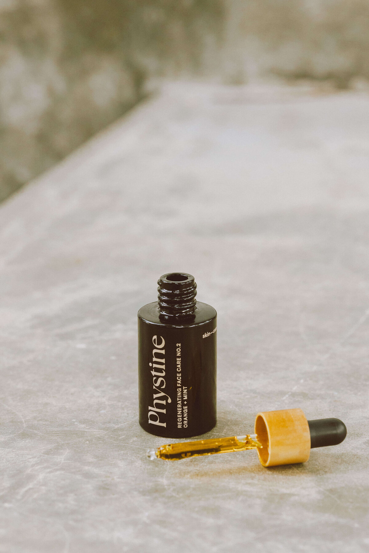 Skin care brand photography of skincare serum bottle with dropper in minimalist setting