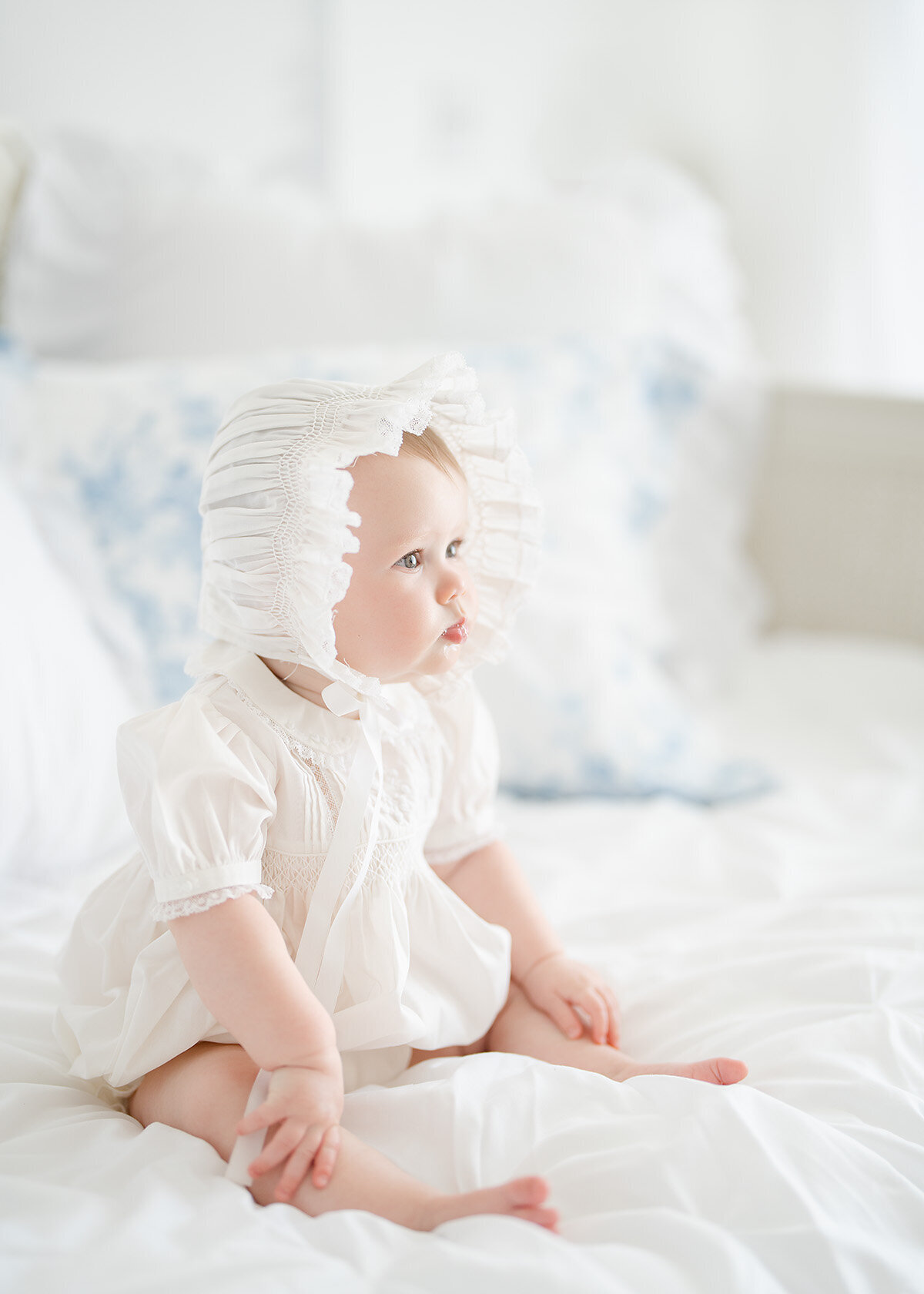 baby girl photographed in feltman brothers outfit and bonnet in a photo studio in brunswick ga for he rmilestone session