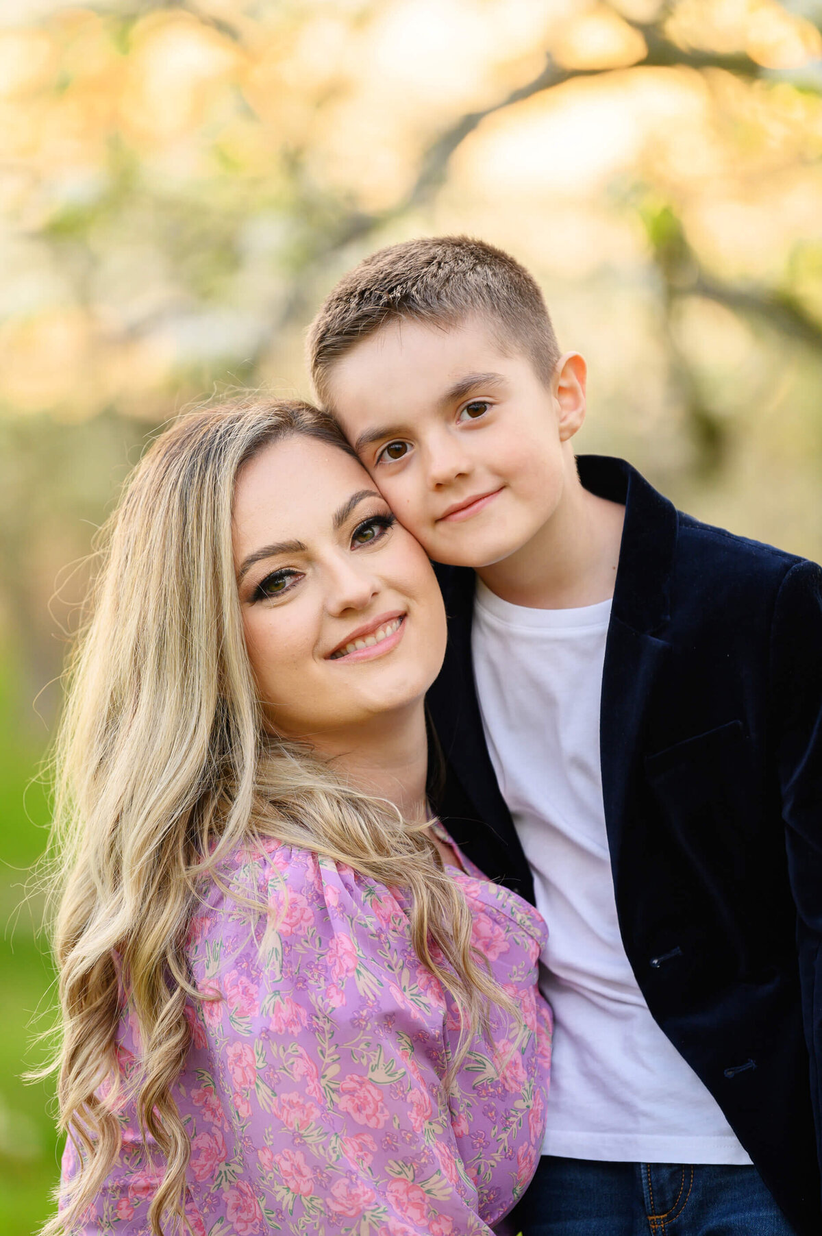 up-close photo of mom and son with the golden hour sunset behind them for their outdoor spring family photos