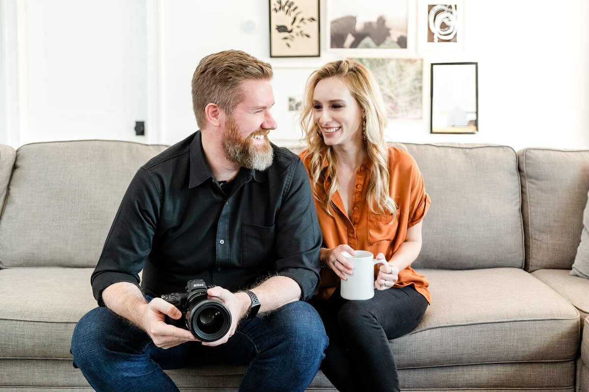 Arizona Wedding Photographers Joy and Ben on couch laughing with camera and mug