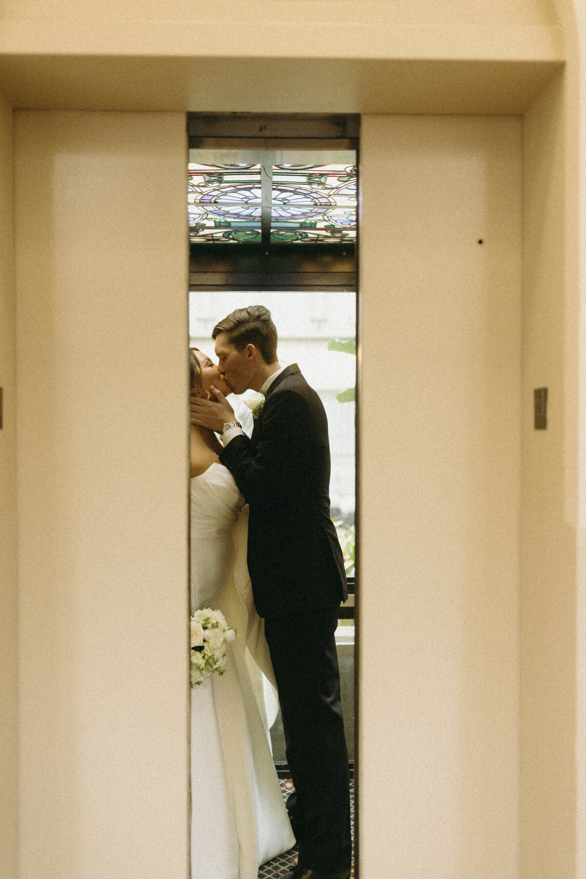 Bride and Groom kissing on the elevator