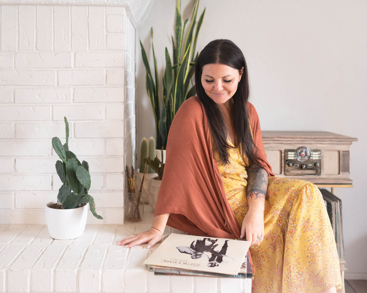 health coach in earthy tones looking at fleetwood mac album showing some of her interests