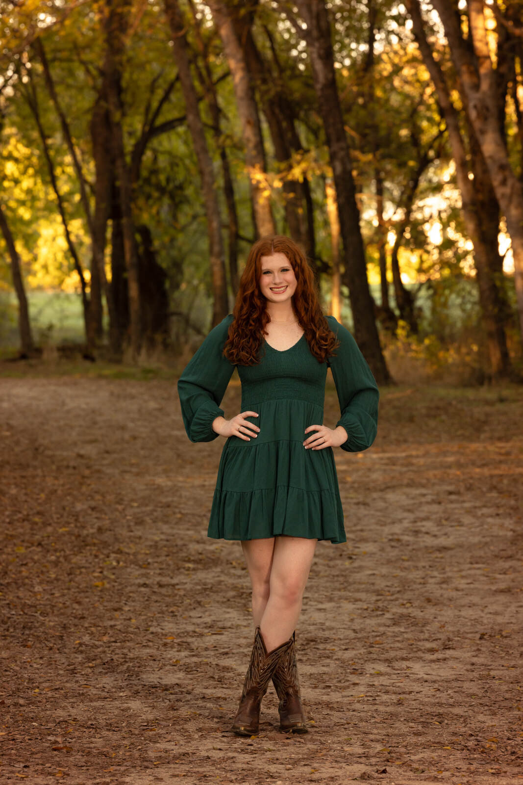 girl-in-green-dress-standing-on-path-with-legs-crossed