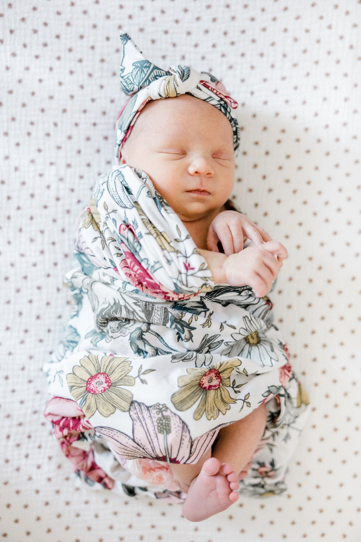 newborn swaddled in floral blanket