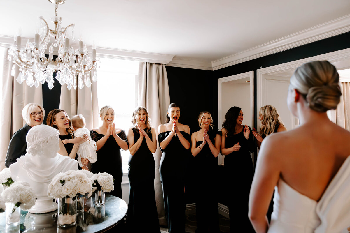 Bride doing a first look with her bridesmaids and their reactions full of smiles and joy