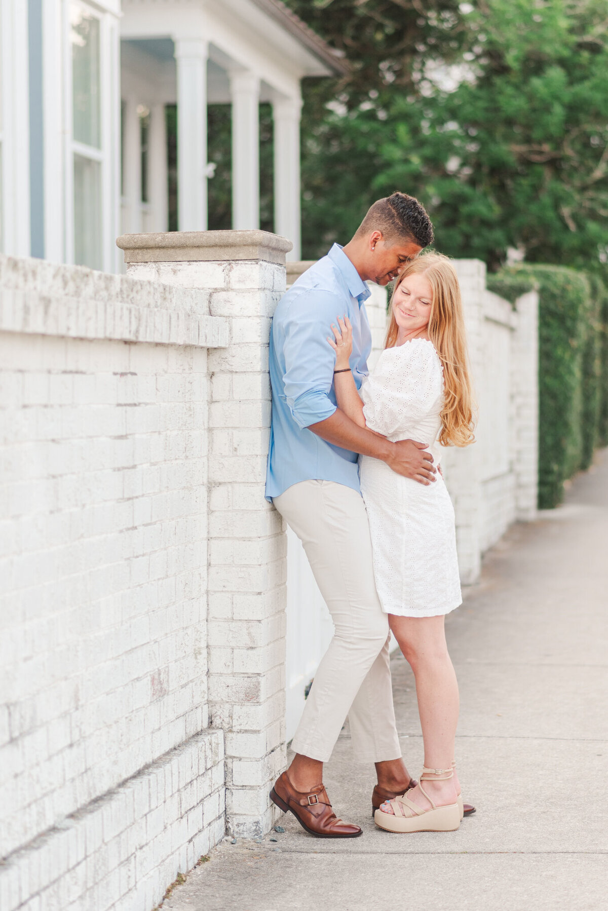 couple kissing during their engagement photos in downtown southport, nc
