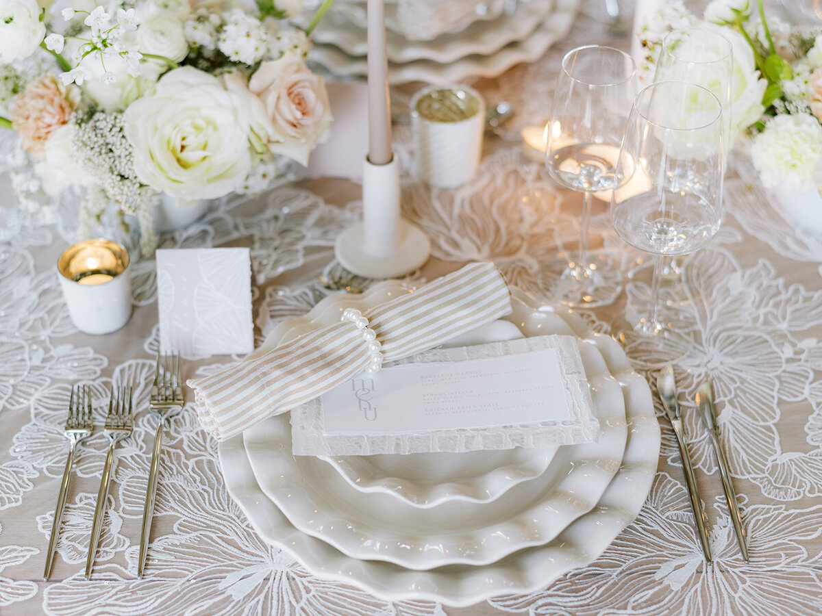 Elegant reception table with dinnerwares, candles and floral centerpiece