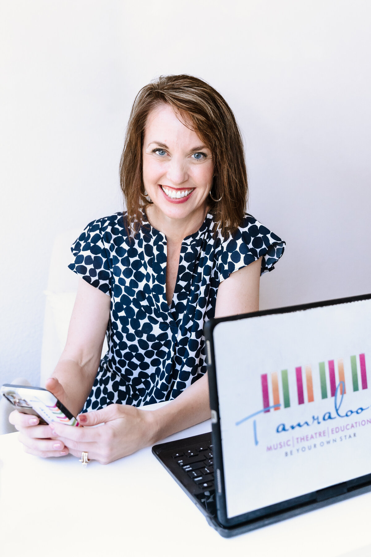 woman posing in her desk, phone on her hands