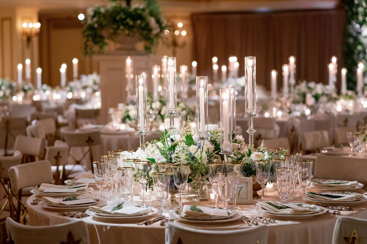 Elegant wedding reception setup with floral centerpieces and candlelit tables.