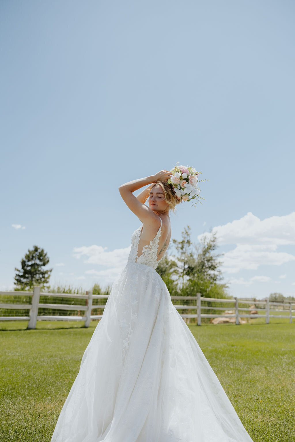 Bride holding her bouquet up on the lawn