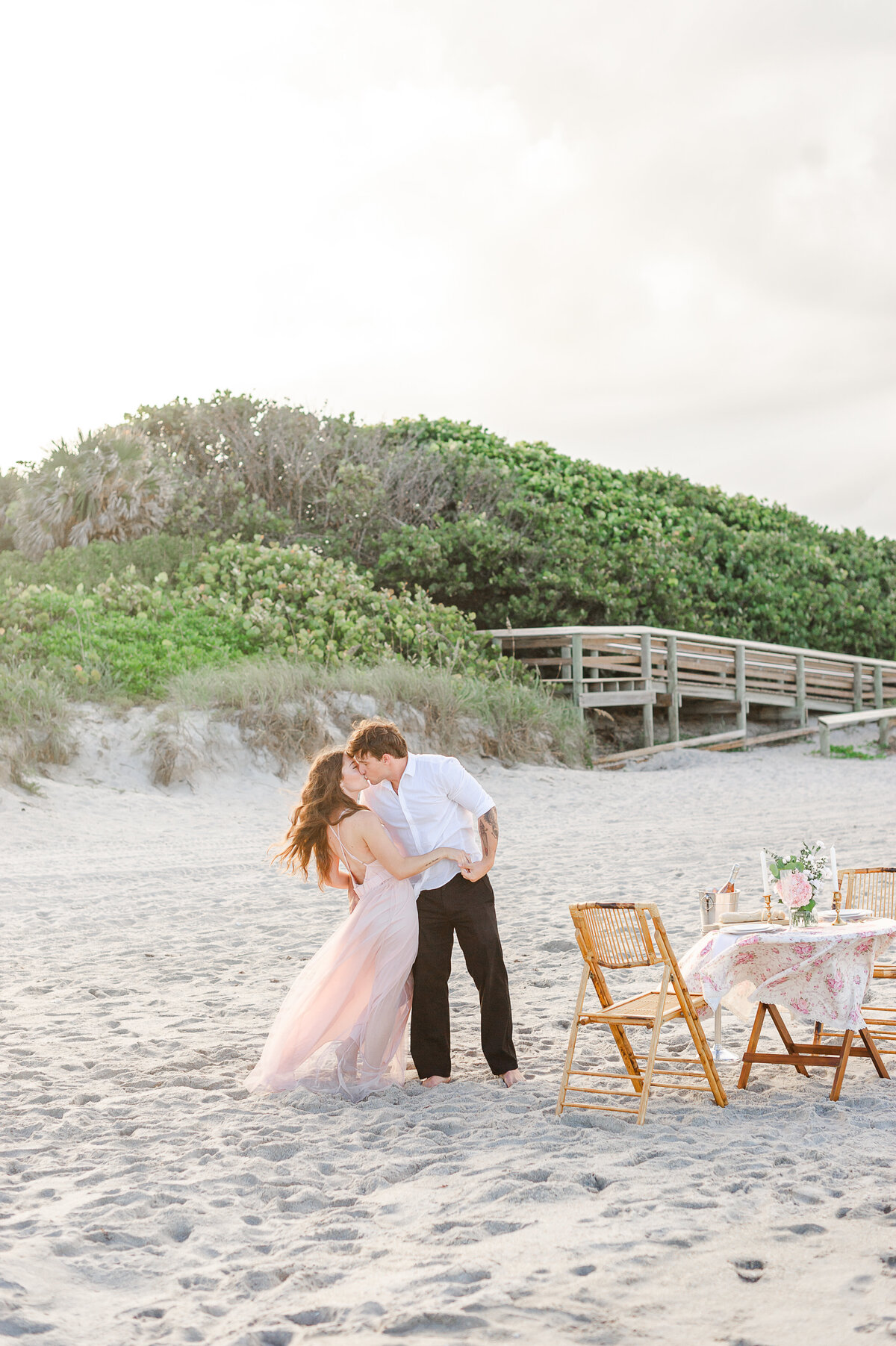 Orlando engagement photographer captures couple in tall grass field kissing