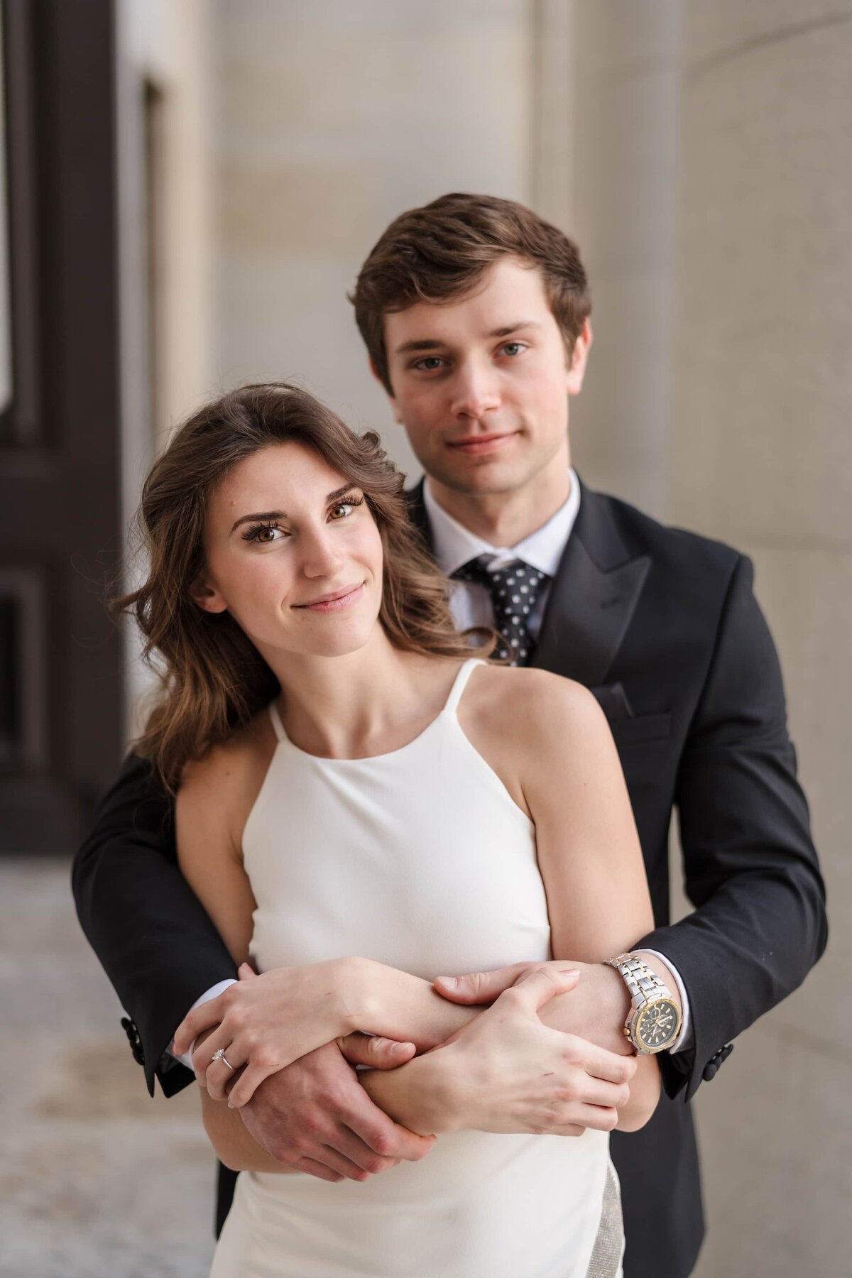 A young man hugs onto his fiance under the columns of the Ohio Statehouse in downtown Columbus