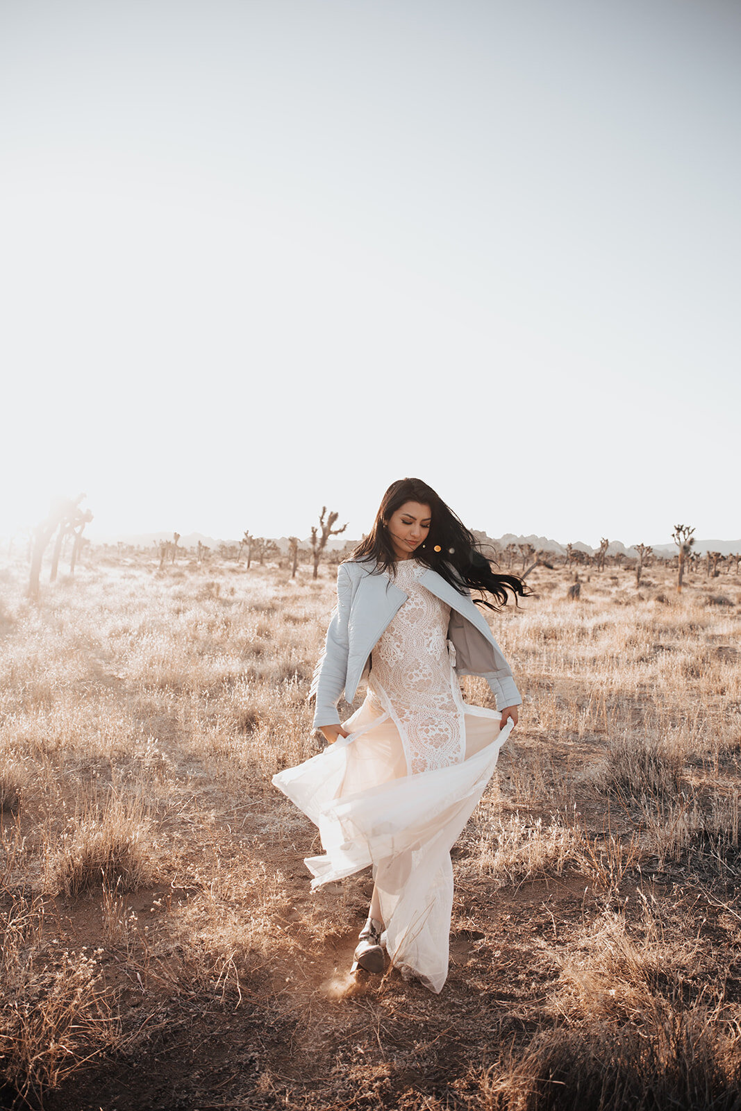 Bride walking in Mojave desert with sun in background