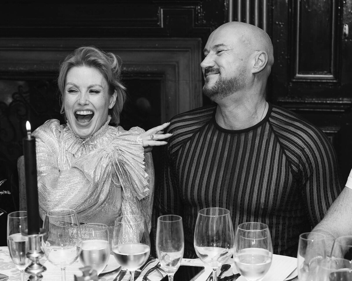a bride laughs with her guest at a wedding.