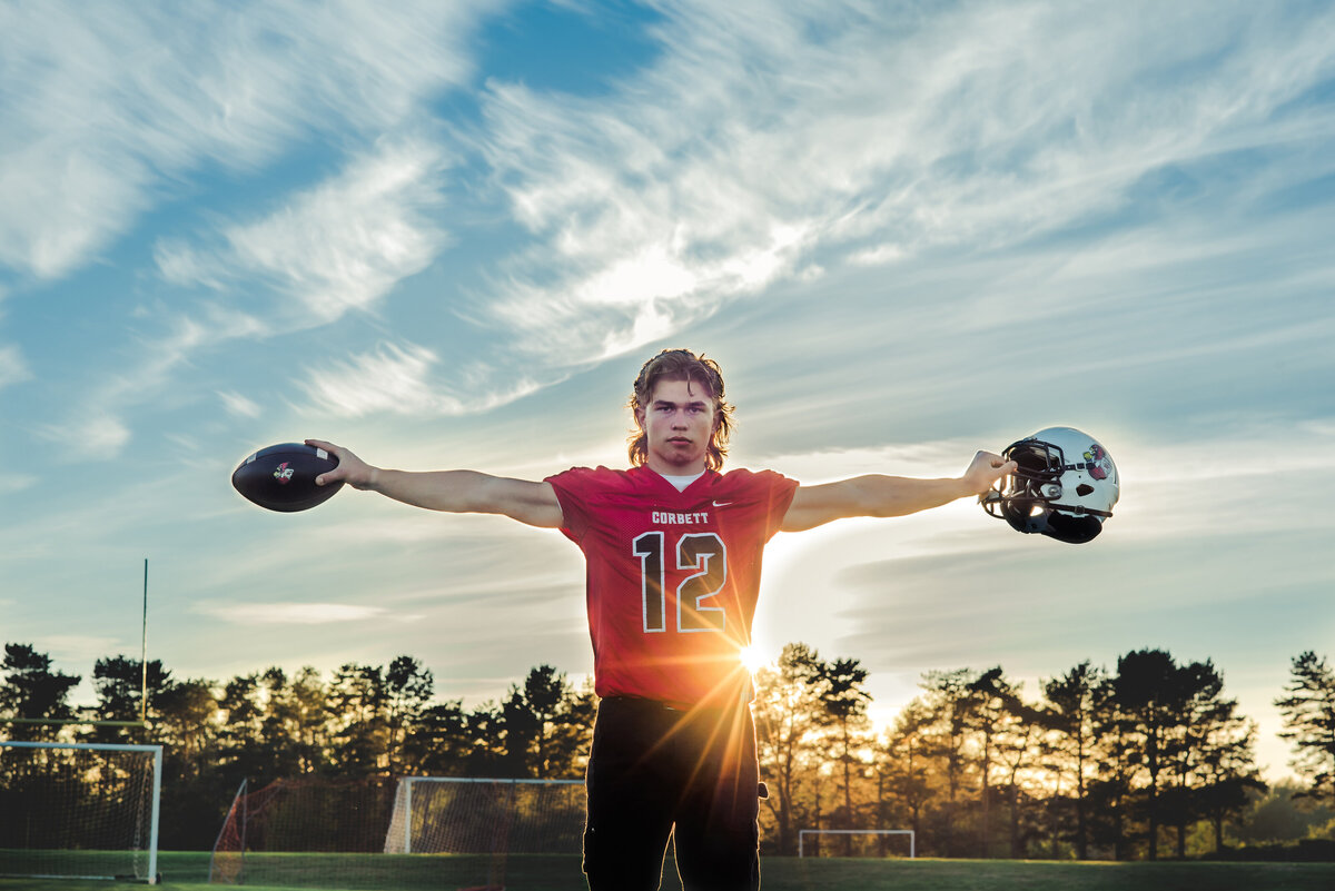 senior boy with football in sun