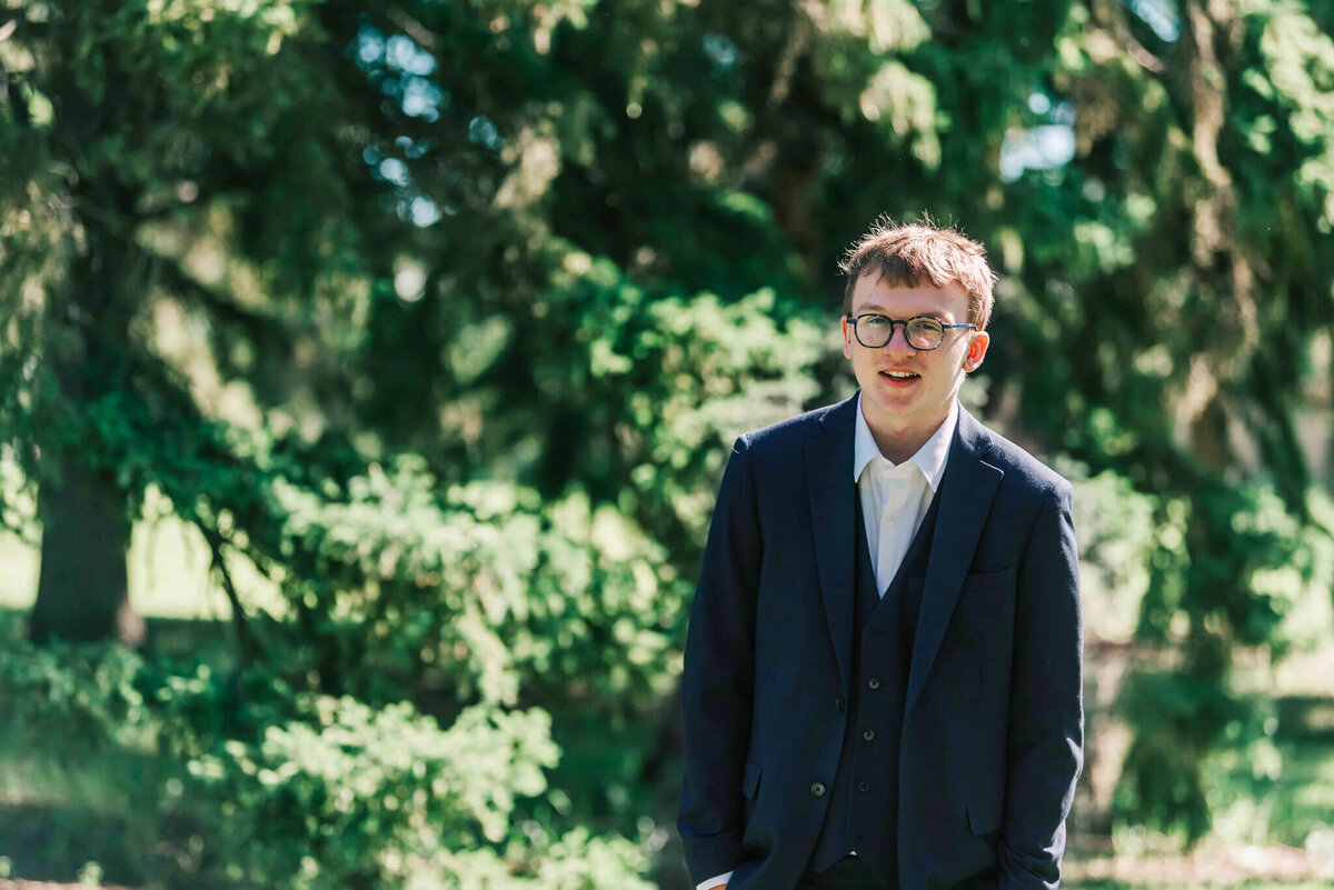 A hip up portrait of a young man in his suit. 