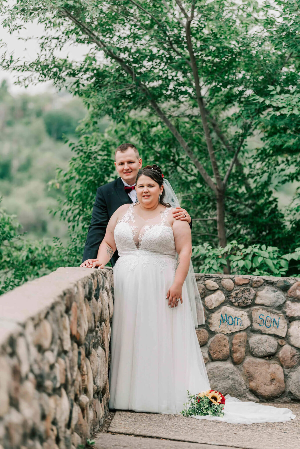 Bride stands in front of her groom.