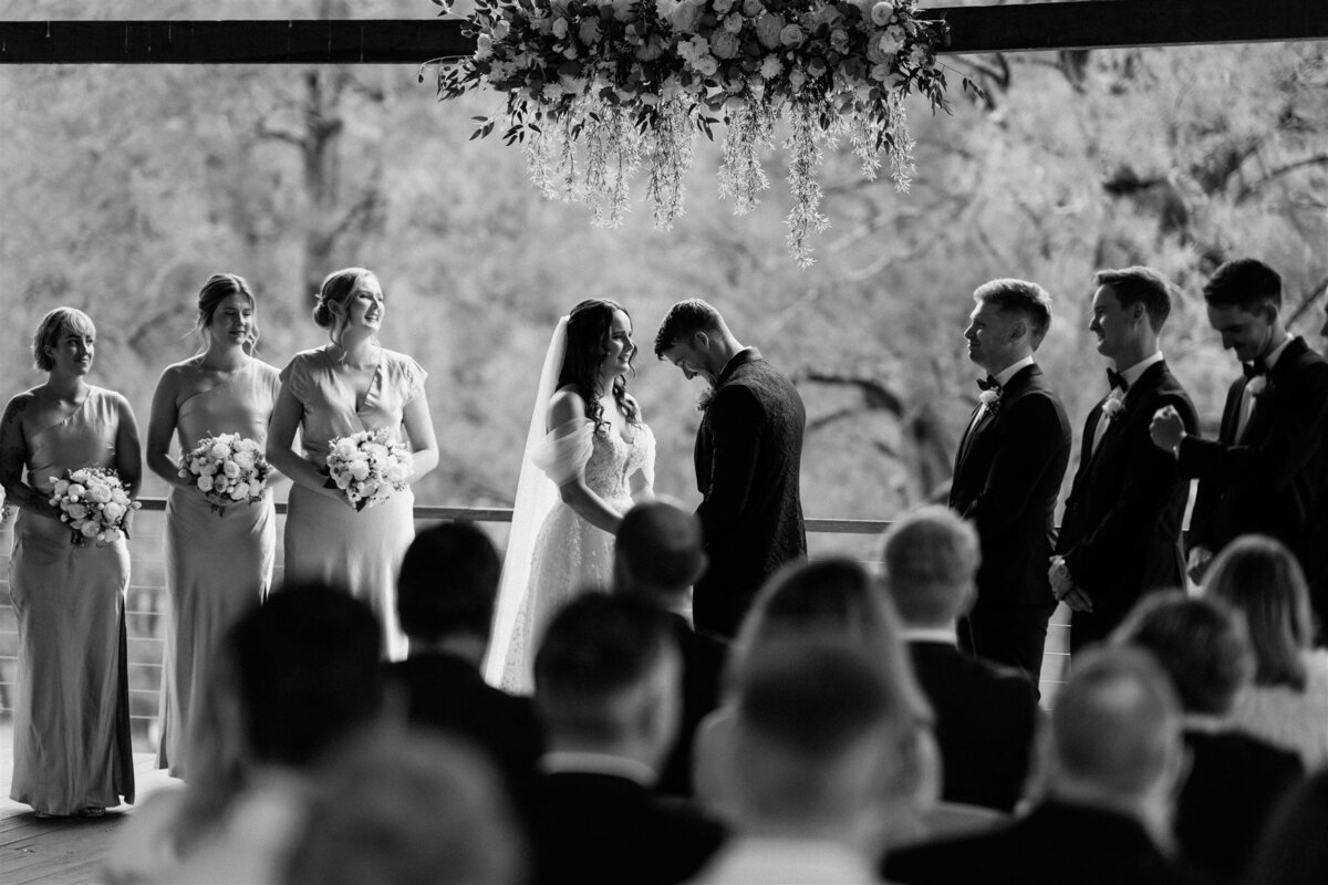 A couple stands lovingly at their ceremony, exchanging vows with heartfelt emotion.