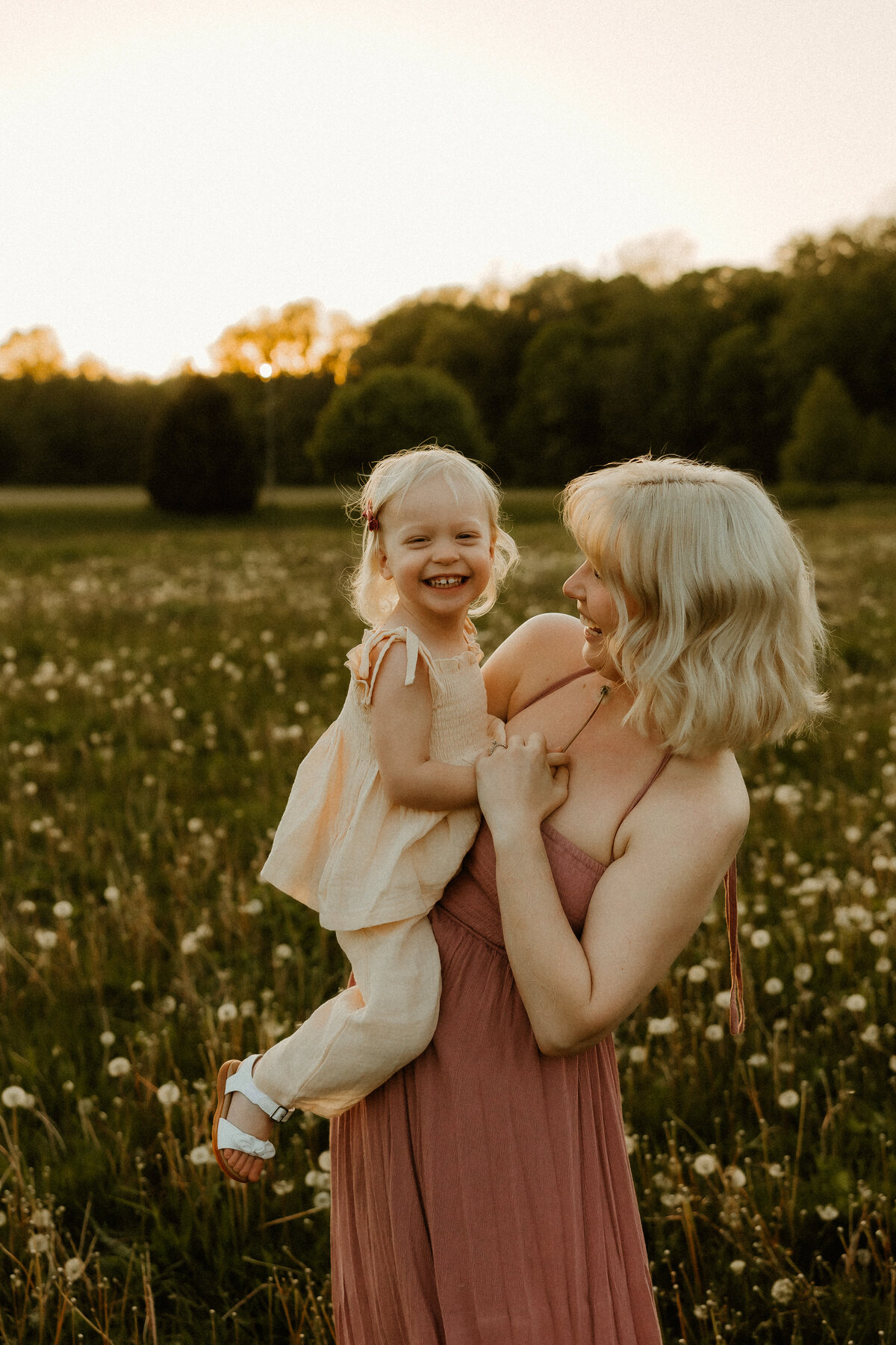 mom and me photo twirling around laughing outside during golden hour