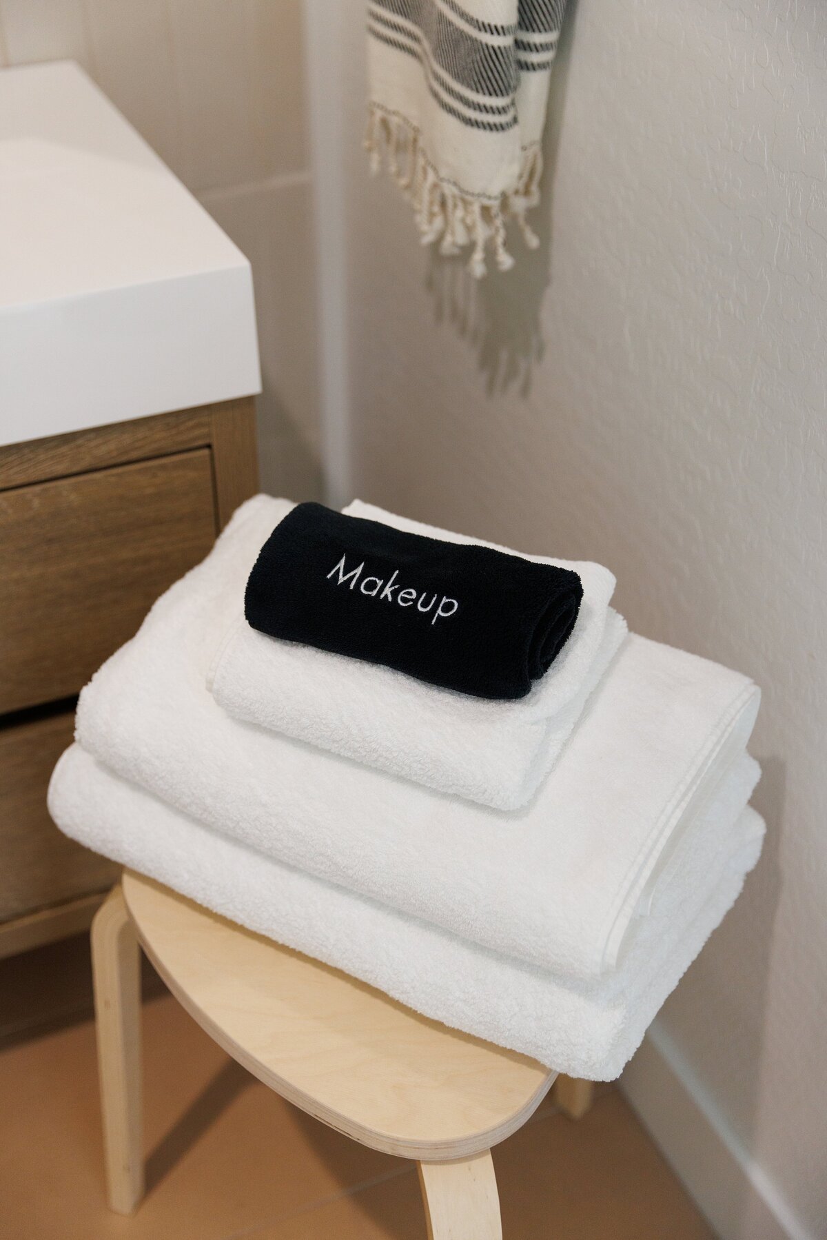 stack of towels on wooden stool in luxury bathroom