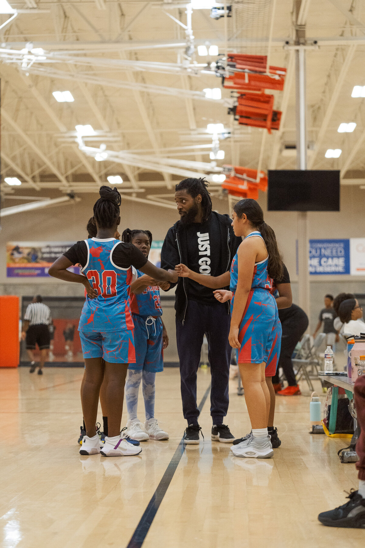 Coach from Full Circle Basketball TX guiding players during a youth basketball game in Fort Worth.